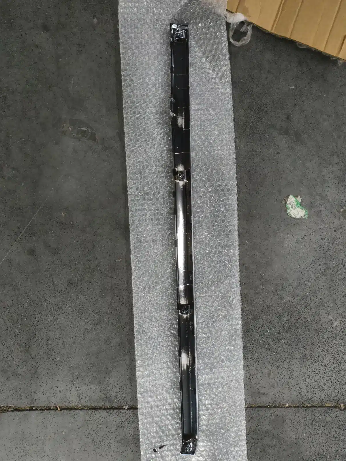 Rear side of a GWM WEY Mocha door sill trim showing clips and locating points