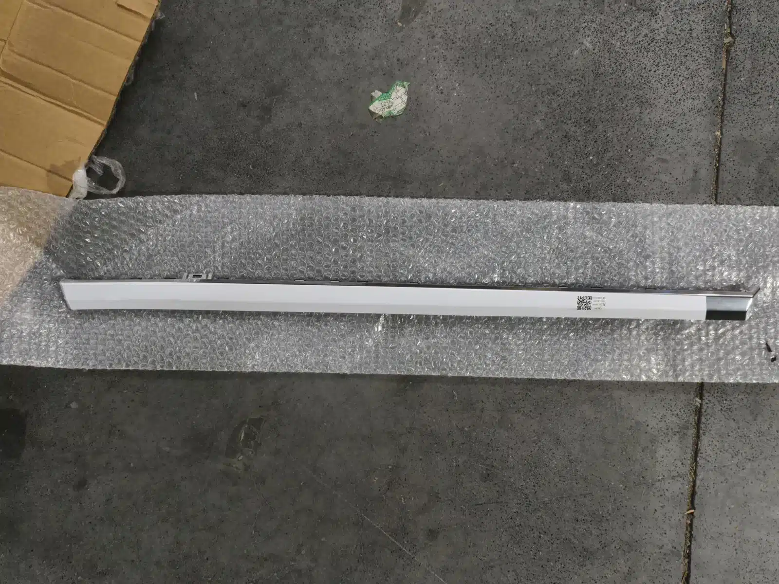 Visible face of a GWM WEY Mocha door sill trim laid on protective bubble wrap